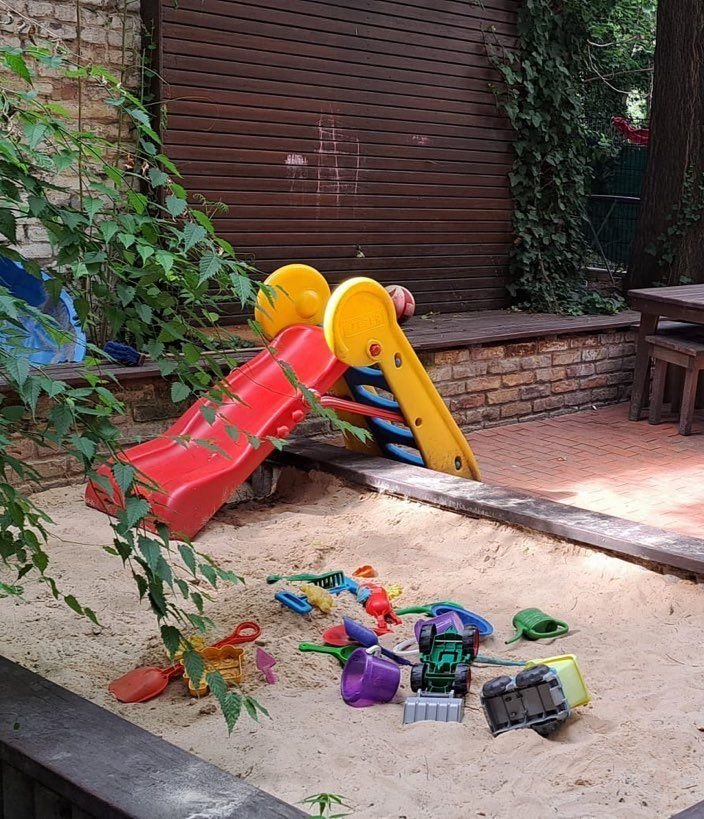 Rote Rutsche und Sandkasten in unserem Hof